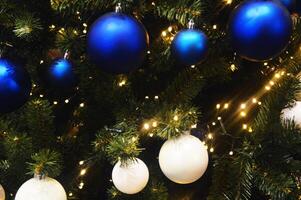 Festive background - blue and white balls on a Christmas tree. New Year's decor. photo