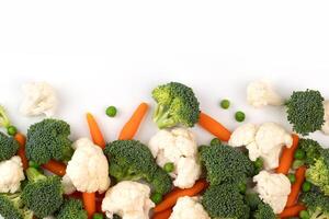 el mezcla crudo vegetal. plano laico de Fresco crudo orgánico vegetales en blanco antecedentes - brócoli, zanahorias, guisantes, coliflor. foto