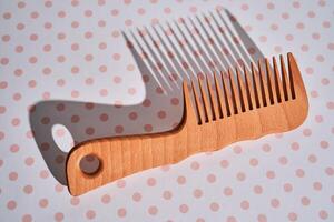 Wooden comb on a pink polka dot background. photo