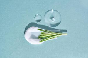 A smear of cream with rosemary and drops of serum on a blue background. photo