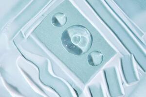 A smear with drops of serum on a blue background. photo