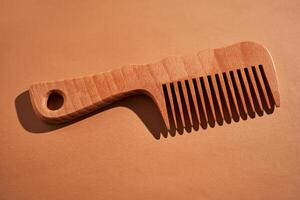 Wooden comb on a beige background. photo
