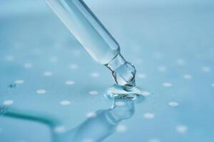 Pipette with serum on a blue background. photo