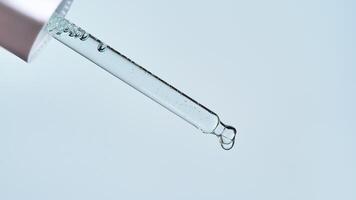 Pipette with serum on a blue background. photo