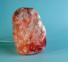 Orange salt lamp. When heated, the air is enriched with useful substances. Healthy lifestyle concept. photo