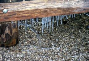 Icicles between the bridge and the surface of Lake Traunsee in Austria. photo