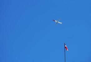 Austrian flag and airplane against the blue sky on a sunny day. photo