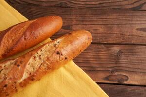 two crispy french baguettes lie on an old wooden table with free space for text photo