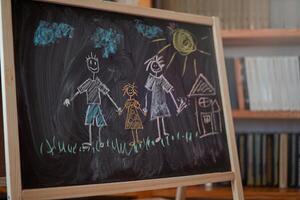 Children multicolored chalk drawing on blackboard photo