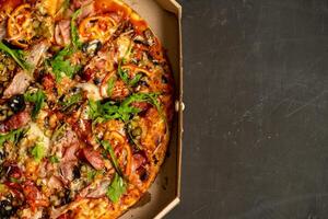 Appetizing pizza with smoked sausages bacon meat tomato cheese arugula photo