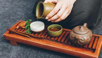 Traditional tea ceremony close up with woman hand photo