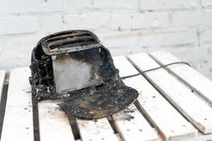 Burning toaster. Toaster with two slices of toast caught on fire over white background photo