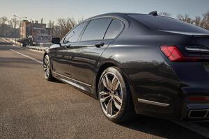 Black city car driving on the road, modern car background photo