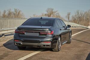 Black city car driving on the road, modern car background photo