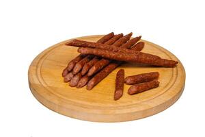 Sausage roasted on the grill on a round board isolated on a white background photo