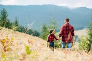 Happy father and little child are walking in the mountains. Father's Day. vacation in the national park photo