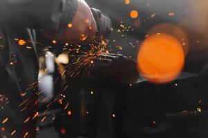 sawing metal. sparks frying over the working table during metal grinding photo