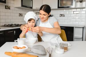 contento familia. madre enseñando su hijo cómo a Cocinando pastel menú en Mañana. sano estilo de vida concepto.. horneando Navidad pastel y cocinar concepto foto