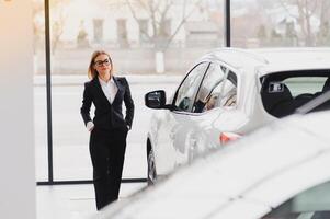 business woman in auto salon. concept of female driver photo