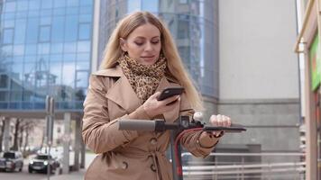 en ung kvinna hyror elektrisk skoter använder sig av mobil telefon app. turist telefon Ansökan. modern gadgetar för ung människor och företag människor video