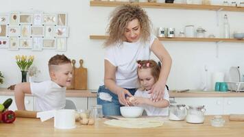 dotter och mor ha sönder ett ägg i en skål. kreativitet och matlagning för barn. moderskap. familj av blondiner i vit t-tröjor och jeans video