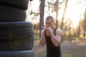 hombre combatiente formación boxeo al aire libre aptitud rutina de ejercicio foto