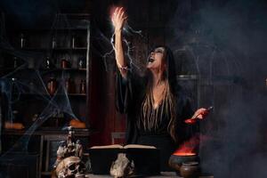 Halloween, witch use magic book and cauldron prepare poison or love potion photo