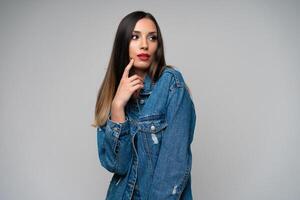 hermosa caucásico niña en un mezclilla chaqueta posando en el estudio en un blanco antecedentes. foto