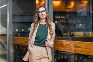 negocio mujer restaurante propietario vestido elegante traje pantalón en pie cerca restaurante grande ventana foto