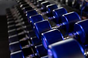 Dumbbells in a row at gym Dark toned photo