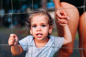 Missing kidnapped, abused, hostage, victim girl alone in emotional stress and pain, afraid, restricted, trapped, call for help, struggle, terrified, threaten, behind a fence locked in a cage cell photo