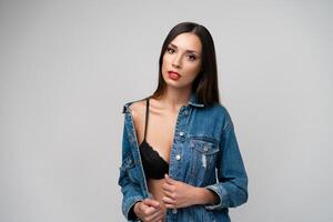 Beautiful caucasian girl in a denim jacket posing in the studio on a white background. photo