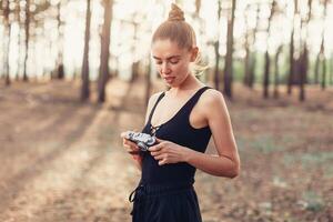 Hipster girl with using vintage photo camera close up, copy space of blank empty mockup, view tourist holding in hands and photograph on device travel on background