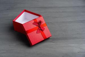 Open Red square holiday gift box against a dark background photo