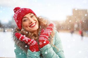 Beautiful lovely middle-aged girl with curly hair warm winter jackets stands ice rink background Town Square. photo