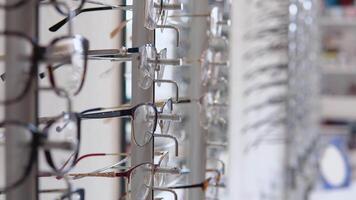 A wide range of different glasses in the store or ophthalmology clinic. Side rack view video