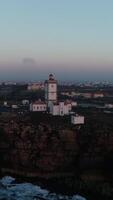 vertical vídeo do cabo carvoeiro dentro Peniche às pôr do sol , Portugal aéreo Visão video