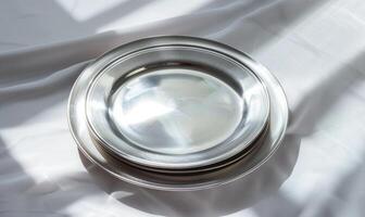 AI generated Set of silver round plates on a white fabric background. Selective focus. photo