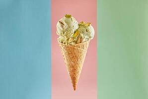 soltero cucharón de pistacho hielo crema en un gofre cono aislado en Tres pastel color antecedentes foto
