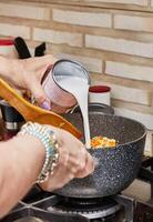 Chef Cooking Delicious Couscous Soup with Fresh Greens on Gas Stove photo