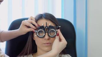 le médecin ensembles en haut une skiascope pour une Jeune femme dans une confortable blanc chandail dans un optique clinique video