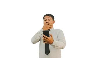 Adult Asian man showing scare and shocked expression when looking to his mobile phone photo