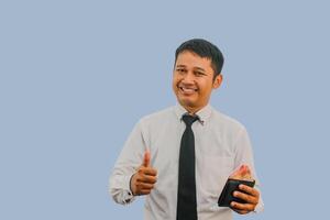 Adult Asian man smiling while holding wallet with money and give thumb finger sign photo