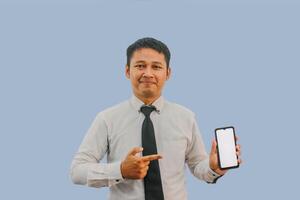 Adult Asian man smiling confident while pointing to empty handphone screen that he hold photo