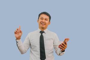 Adult Asian man smiling and pointing finger up while holding indonesian rupiah paper money photo