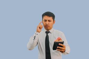 Adult Asian man showing thinking expression while holding wallet full money photo