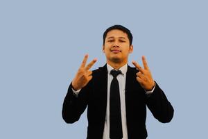 Adult Asian man smiling at the camera and doing two fingers sign photo