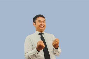 Adult Asian man clenching both hands showing excited expression photo
