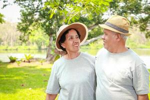 Asian elderly couple Take a vacation in the park. Enjoy life after retirement. The concept of health for the elderly. copy space photo