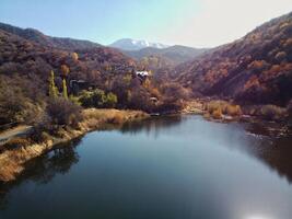 aéreo ver de montañas y lago. otoño foto de alta altitud paisaje con oro, naranja arboles y alpino lago. hermosa asiático naturaleza